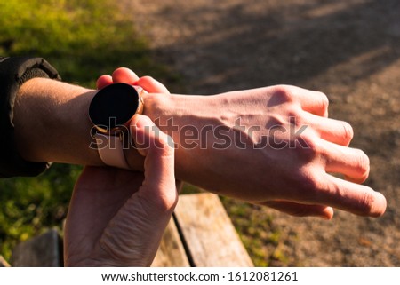 Woman holding smart watch on wrist outdoor