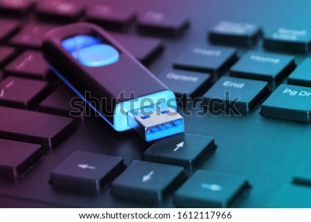 Blue 3.0 USB flash on a computer keyboard - toned with purple bluish light Royalty-Free Stock Photo #1612117966
