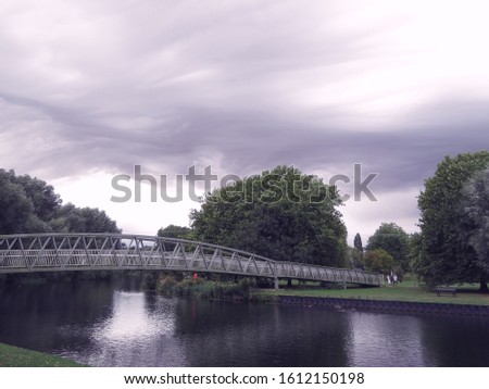 Asperitas clouds cover the sky over St Neots in Huntingdonshire, Cambridgeshire, England over the River Great Ouse with trees and a bridge