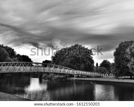 Asperitas clouds cover the sky over St Neots in Huntingdonshire, Cambridgeshire, England over the River Great Ouse with trees and a bridge