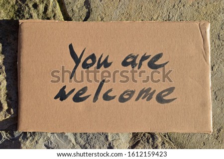 Cardboard sign saying: You are welcome