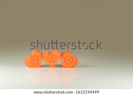 Heart shaped carrot slices. Symbolizing: a love triangle, three hearts, betrayal or LGBT. Relationships shown using vegetable pieces. Carrots like a 2 + 1 family (parents and child).