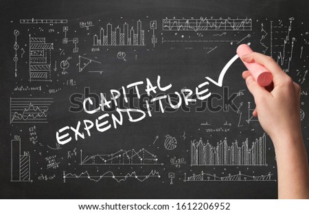 Hand drawing CAPITAL EXPENDITURE inscription with white chalk on blackboard, new business concept