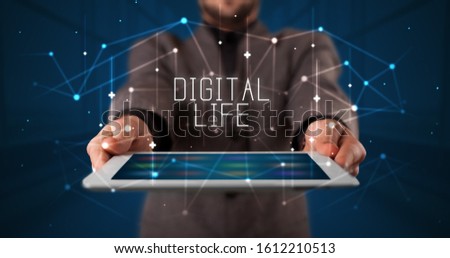 Young business person working on tablet and shows the digital sign: DIGITAL LIFE