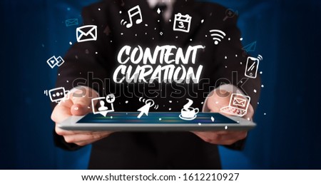 Young business person working on tablet and shows the inscription: CONTENT CURATION Royalty-Free Stock Photo #1612210927