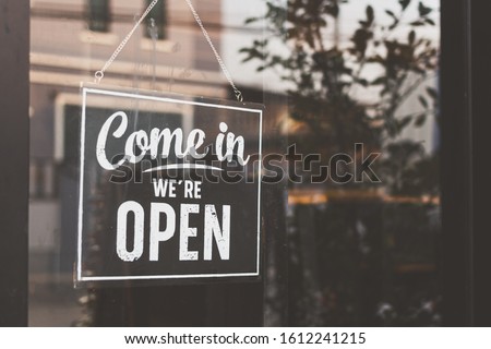Text on vintage black sign "Come in we're open" in cafe. Royalty-Free Stock Photo #1612241215