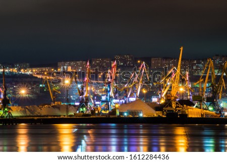 night Murmansk, city lights reflected in the Bay and the ships standing in the port