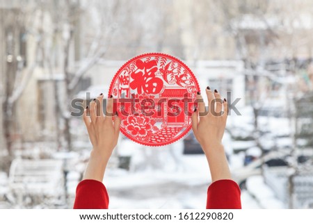 The Spring Festival couplets on the window（Translation:blessing,Fook lam moon,Good luck,Bamboo to report the safety of thousands,Flowers and wealth usher in the New Year.） Royalty-Free Stock Photo #1612290820