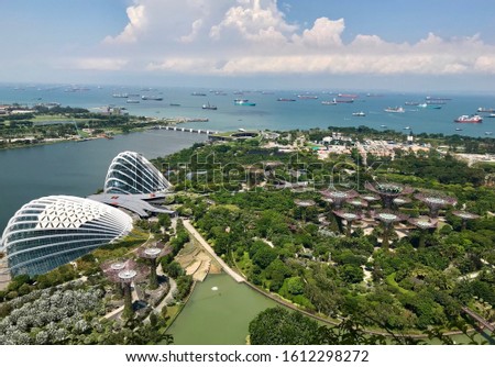 Gardens by the bay before ocean, with containerships in background, from rooftop on skyscraper, Singapore, South East Asia