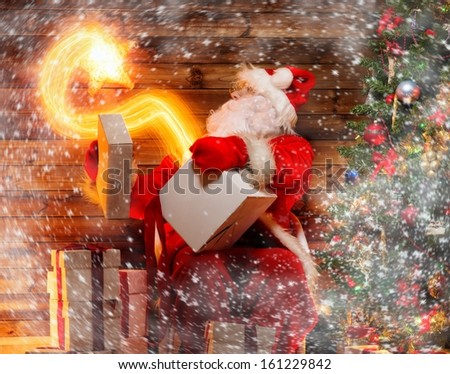 Santa Claus in wooden home interior holding gift box with magic star flying out of it 