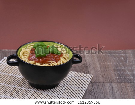Spaghetti pasta with tomato sauce on wooden table stock images. Bowl of spaghetti. Spaghetti with basil on a wooden background with copy space for text. Spaghetti top view with copy space