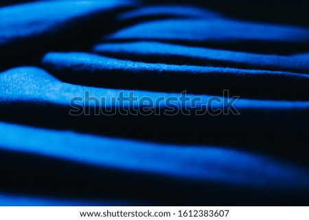 Blue felt berets lined with steps create a play of light and shadow creating an abstraction