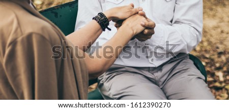 Lovely senior elderly smiling couple man and woman holding hand as promising of forever love or take care in romantic moment. Warm heart marriage and lover bonding and relationship Love photo concept
