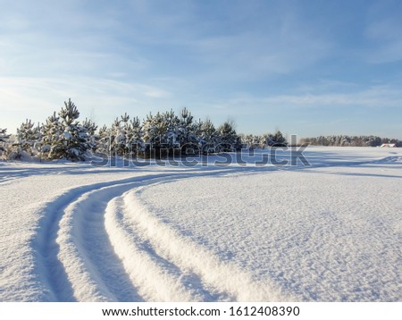 White winter landscape scene with snowy field and road bending to the side covered with a lot of snow in winter. Beautiful winter landscape