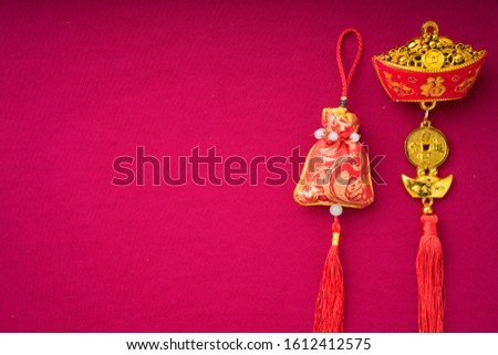 Chinese New Year decorations with red background with assorted festival decorations. Inscribed Chinese characters means abundant of wealth, prosperity and luck. Flat lay.