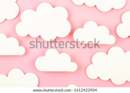 White paper cut out clouds over pink background. Flat lay, mock up, copy space