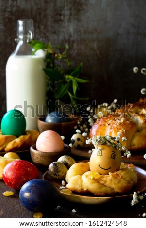 Easter pastries background. Colored eggs on a wooden table. Copy space.