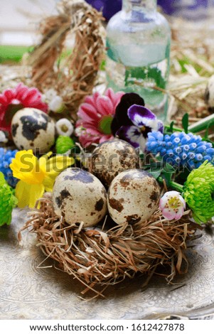 A decorative nest made of hay with quail eggs inside. Easter table decoration. 
