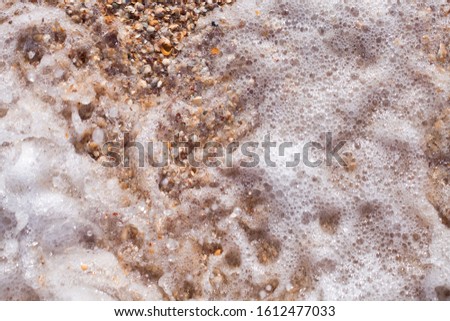 
Sea foam ashore from small shells