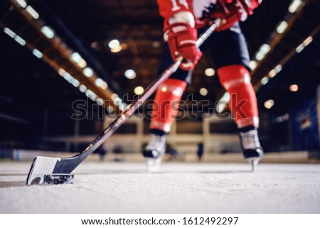 Close up of hockey player skating with stick and puck. Royalty-Free Stock Photo #1612492297