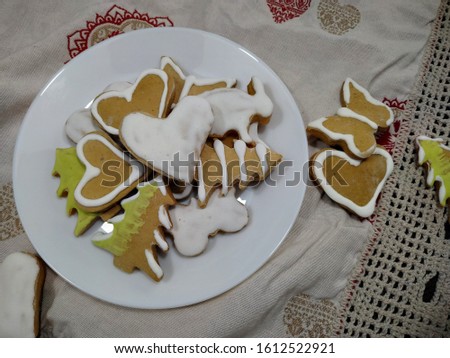 
Gingerbread homemade cookies on a plate that stands on a holiday tablecloth