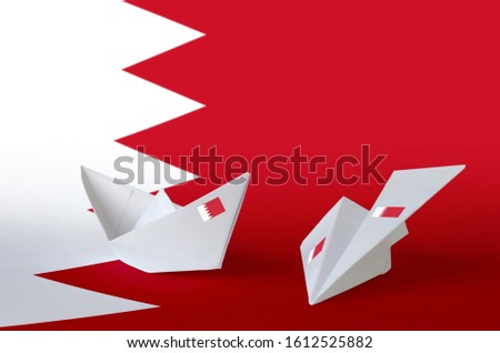 Bahrain flag depicted on paper origami airplane and boat. Handmade arts concept