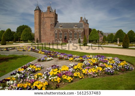 moated castle, bridge and large formal garden with pansies, Viola, flower borders