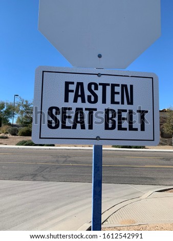 Fasten Seat Belt sign on back of stop sign post