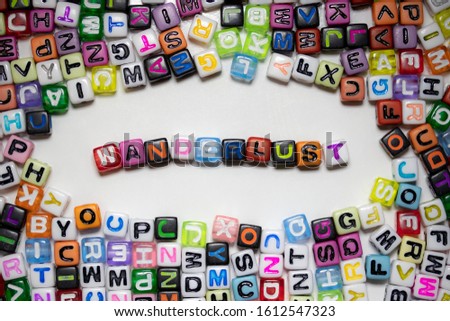 The word WANDERLUST written on colorful cubes isolated on a white background...