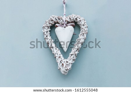 Valentine's card  background - A white wooden heart surrounded by a wicker wreath on a pastel background. The perfect decoration for Happy Valentine's Day or for a wedding. A nice gift for lovers. 