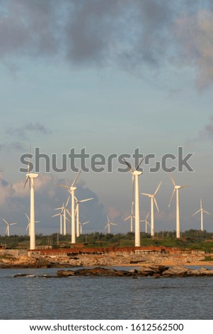 Seaside wind turbines in the sunrise sky background