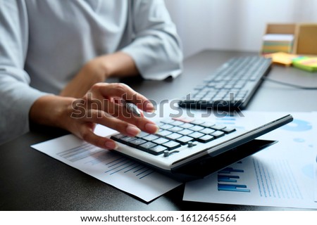 Blurred hand of Asian woman pressing calculate for prepare information of report to correct. Still holding a paper work of chart to recheck, analyze data for making presentation meeting or discussion
 Royalty-Free Stock Photo #1612645564
