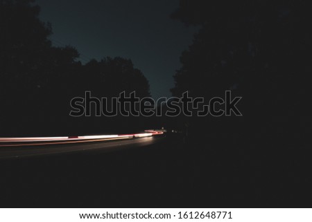 Night long exposure of winding highway with cars passing