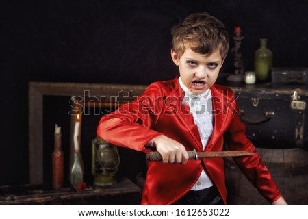 Portrait of a boy dressed as a vampire on a dark background .  Halloween party.