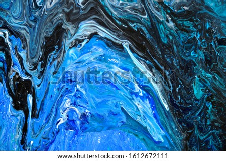 Oil paints spread by transitions of tinting colors of blue, turquoise, black, white on the surface.