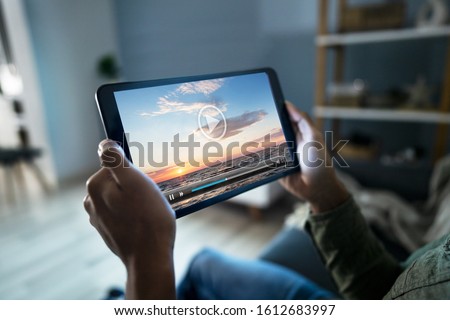 Cropped Image Of Man Watching Movie On Digital Tablet At Home Royalty-Free Stock Photo #1612683997
