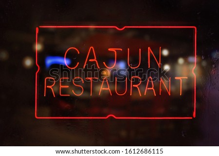Neon Cajun Restaurant Sign in Rainy Window