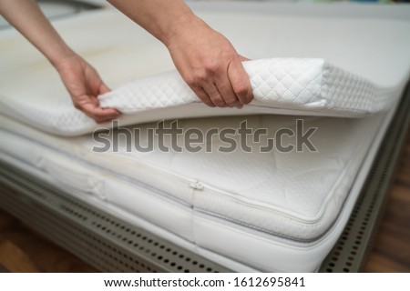Mattress Topper Being Laid On Top Of The Bed Royalty-Free Stock Photo #1612695841