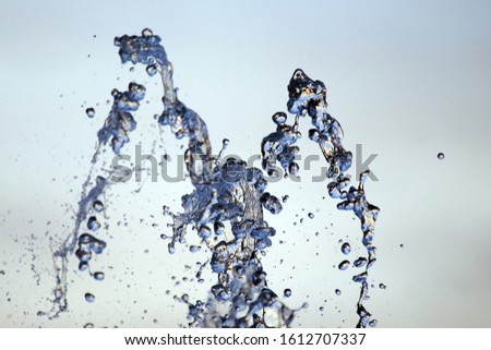 Drops of a falling water fountain against the evening sky. natural textures and backgrounds