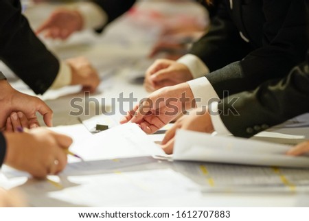 many hands of men are writing information paper