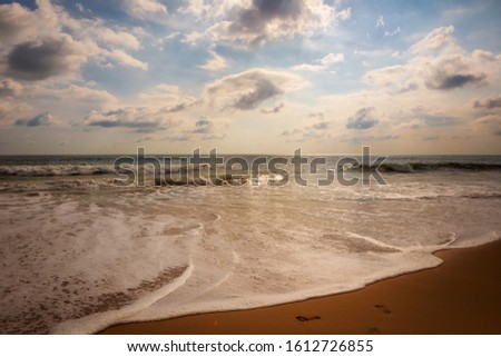 picture of the coastal strip of the ocean, with waves, yellow sand and horizon stretching into the sky. travel and vacation. relaxation, surf noise, deserted beach.