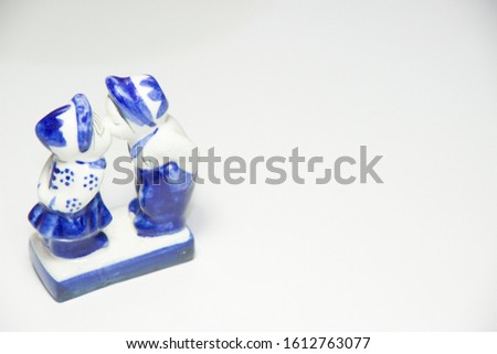 Ceramic Statues Boys and girls kissing each other on white background with copy space. Celebration Saint Valentine's Day.