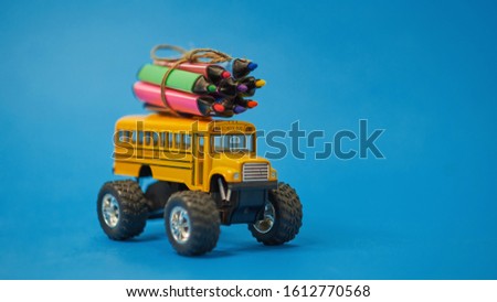 Yellow School bus and felt-tip pens on the roof, back to school concept, yellow background, copy space. education.
