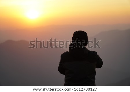 Silhouette lonely cameraman taking a photo during morning sunrise on Doi Pui co viewpoint at Mae Hong Son province amazing Thailand.