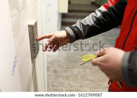 Builder presses elevator button in building under construction