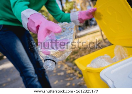 Volunteer girl sorts garbage in the street of the park. Concept of recycling. Zero waste concept. Nature