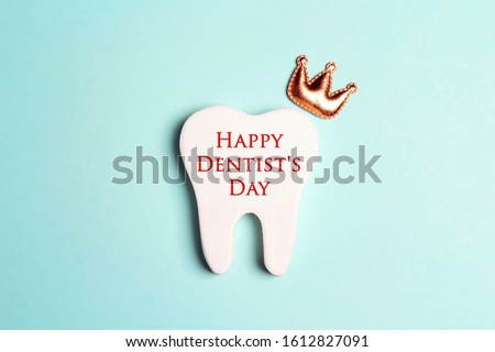 Happy Dentist's Day concept with tooth in the crown on a blue background.