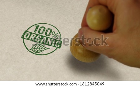 Organic 100 percent stamp and stamping hand. Ecology, bio, gmo free, natural and healthy diet concept.