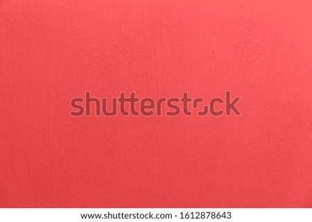 An empty clean concrete wall with an uneven texture is painted pink with brush marks. Used for web design and background