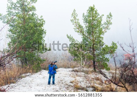 Man photographer who take a picture of misty valley.